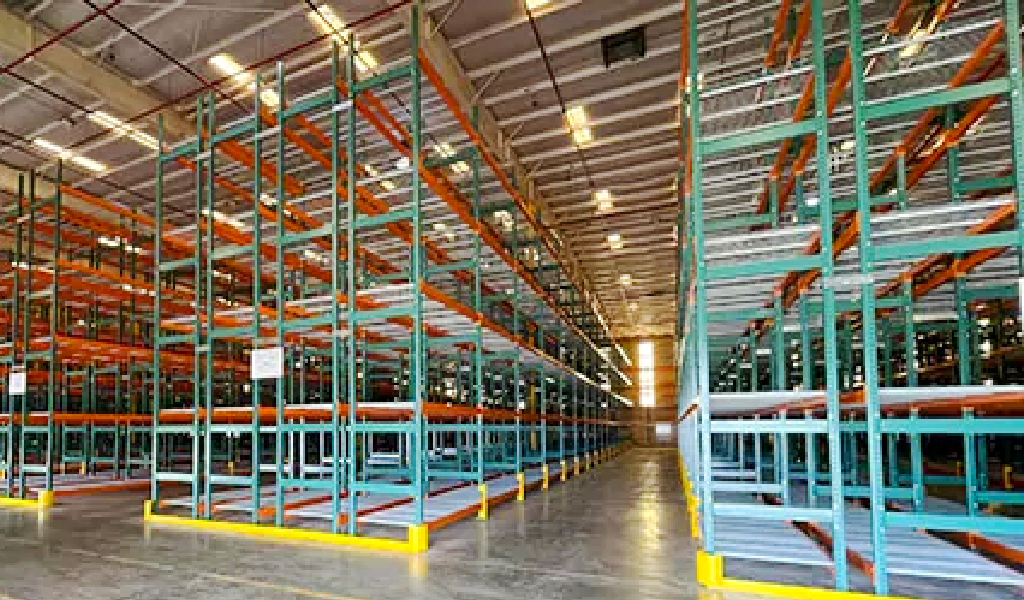 Rows of empty Double-Deep Rack shelving stand inside a large, brightly lit industrial warehouse storage facility.